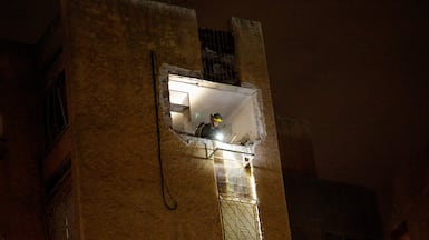 An emergency worker inspects missile damage after an Iranian barrage hit a building in Tel Aviv, Israel. Reuters