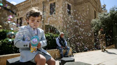 A boy plays with a water gun outside a local church in Beirut. Alamy